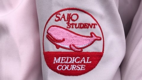 医療系「Student Assistant(スチューデント・アシスタント)」オリジナルロゴです。
「ピンクのくじら🐬」がサポート学生の腕に乗っています!